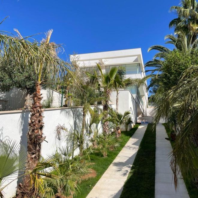 Una casa blanca con palmeras delante