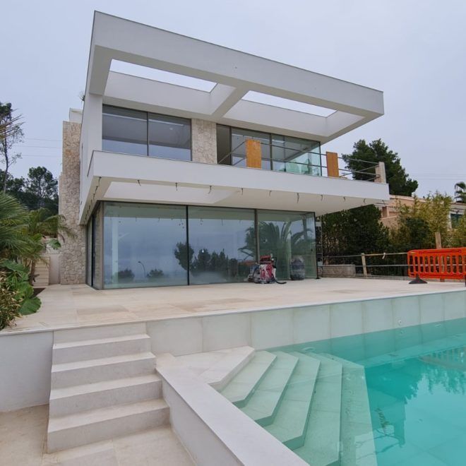 Una casa grande con piscina delante de ella.