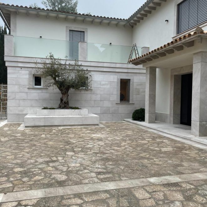 Una casa blanca con un árbol delante