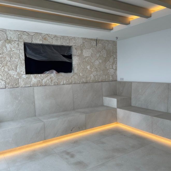 Una sala de estar con un sofá y un televisor en la pared.