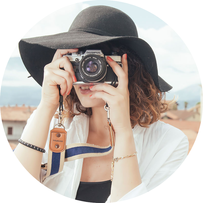 Una mujer con sombrero está tomando una fotografía con una cámara.