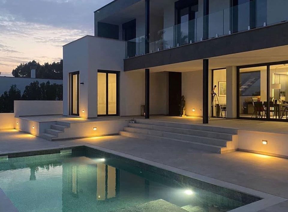 Una casa grande con piscina delante de ella.