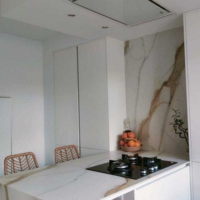 Una cocina con un horno de leña y un bol de naranjas en la encimera.