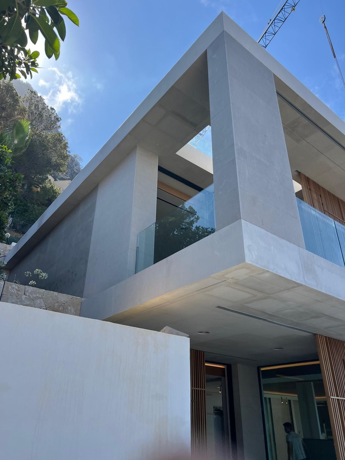Una casa moderna con balcón y un cielo azul al fondo.