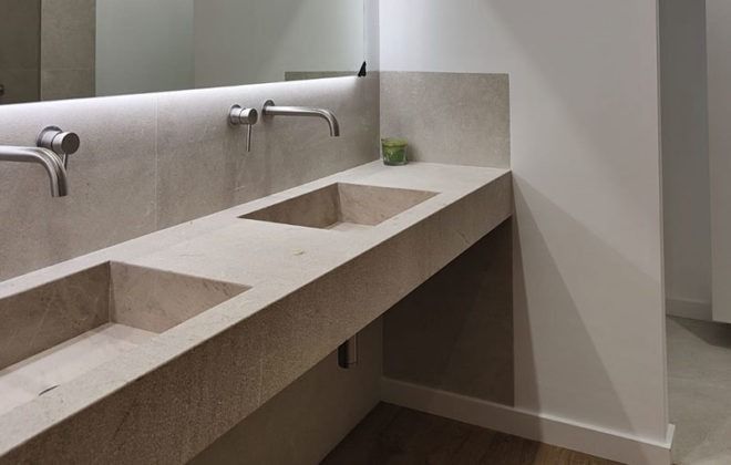 Un baño con dos lavabos y un espejo.
