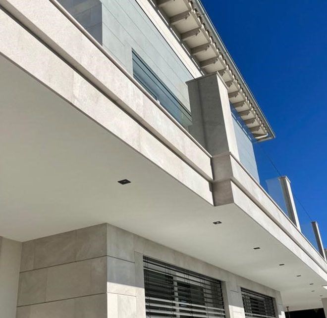 Un edificio con un balcón y un cielo azul al fondo.