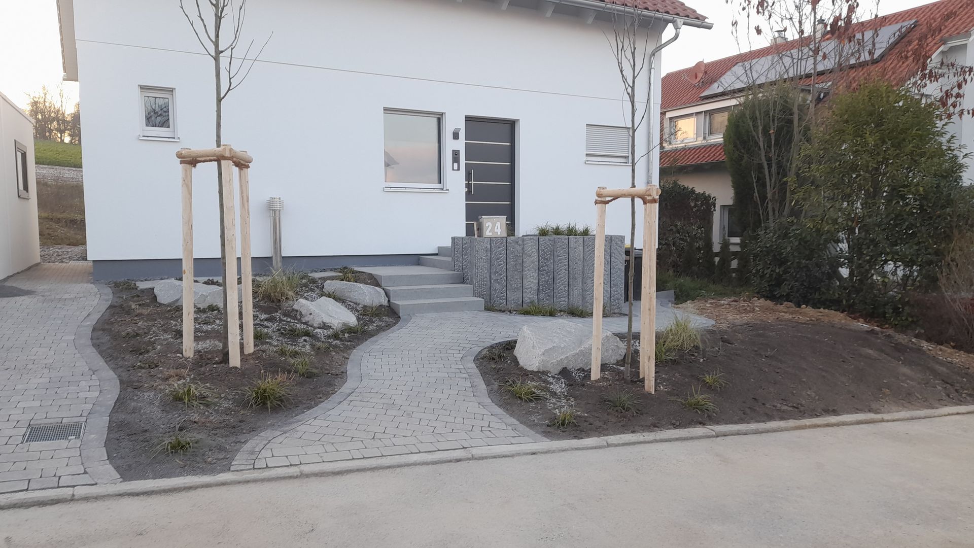 Ein weißes Haus mit einem frisch angelegten Vordergarten
