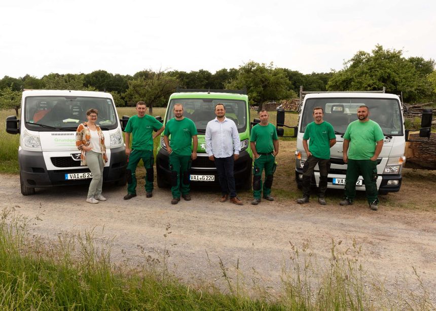 Teamfoto Grundgeiger vor einem grünen Sprinter