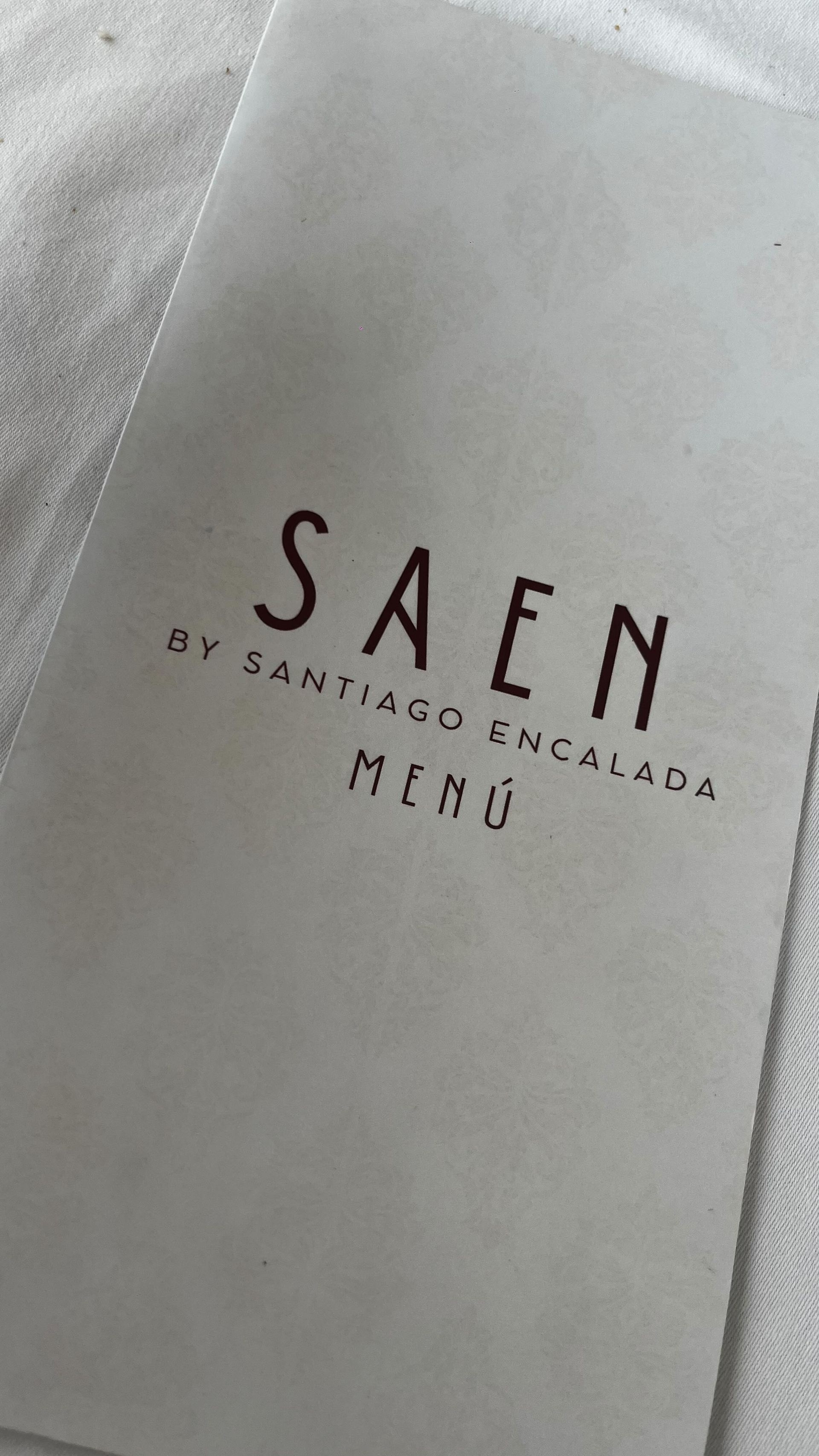 Un menú de un restaurante llamado saen está sobre una mesa.