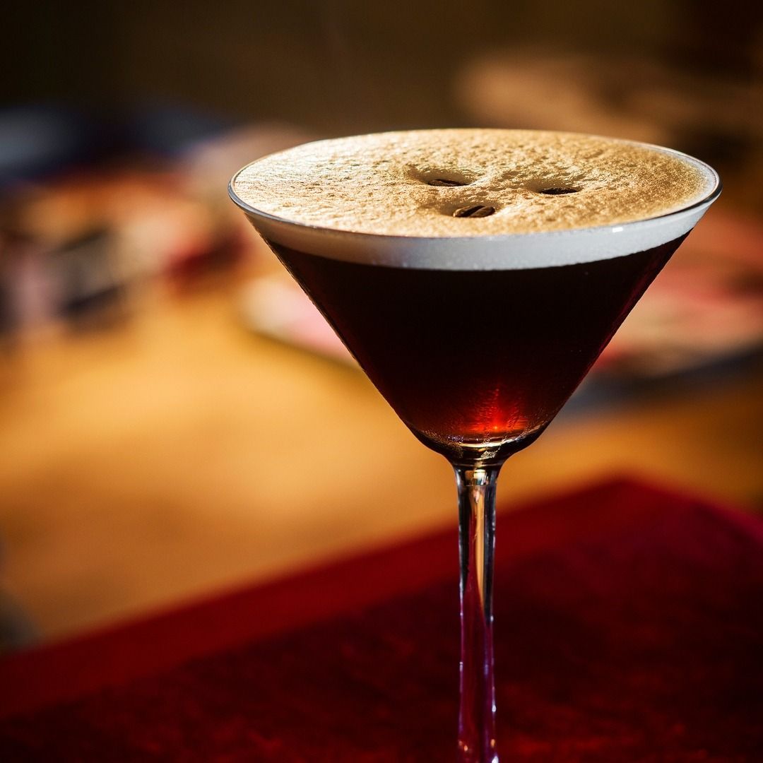 Una copa de martini con un líquido marrón dentro