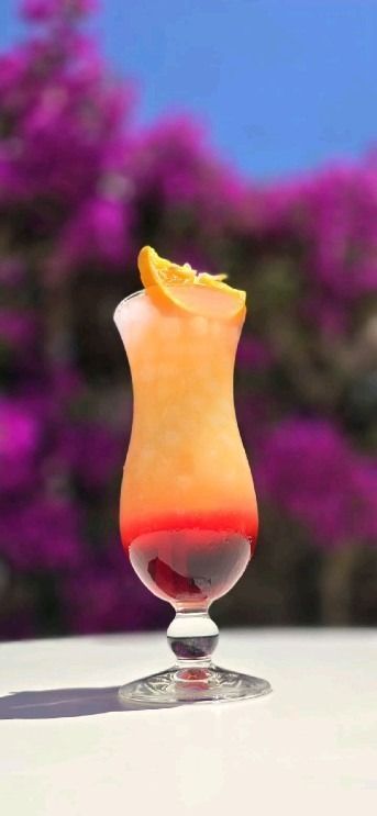 Un primer plano de un cóctel en un vaso sobre una mesa.