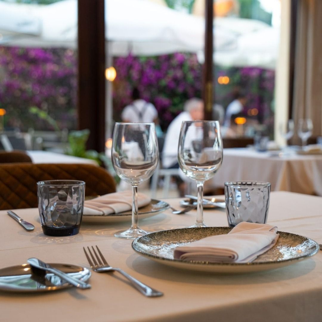 Una mesa de restaurante con platos y vasos encima.