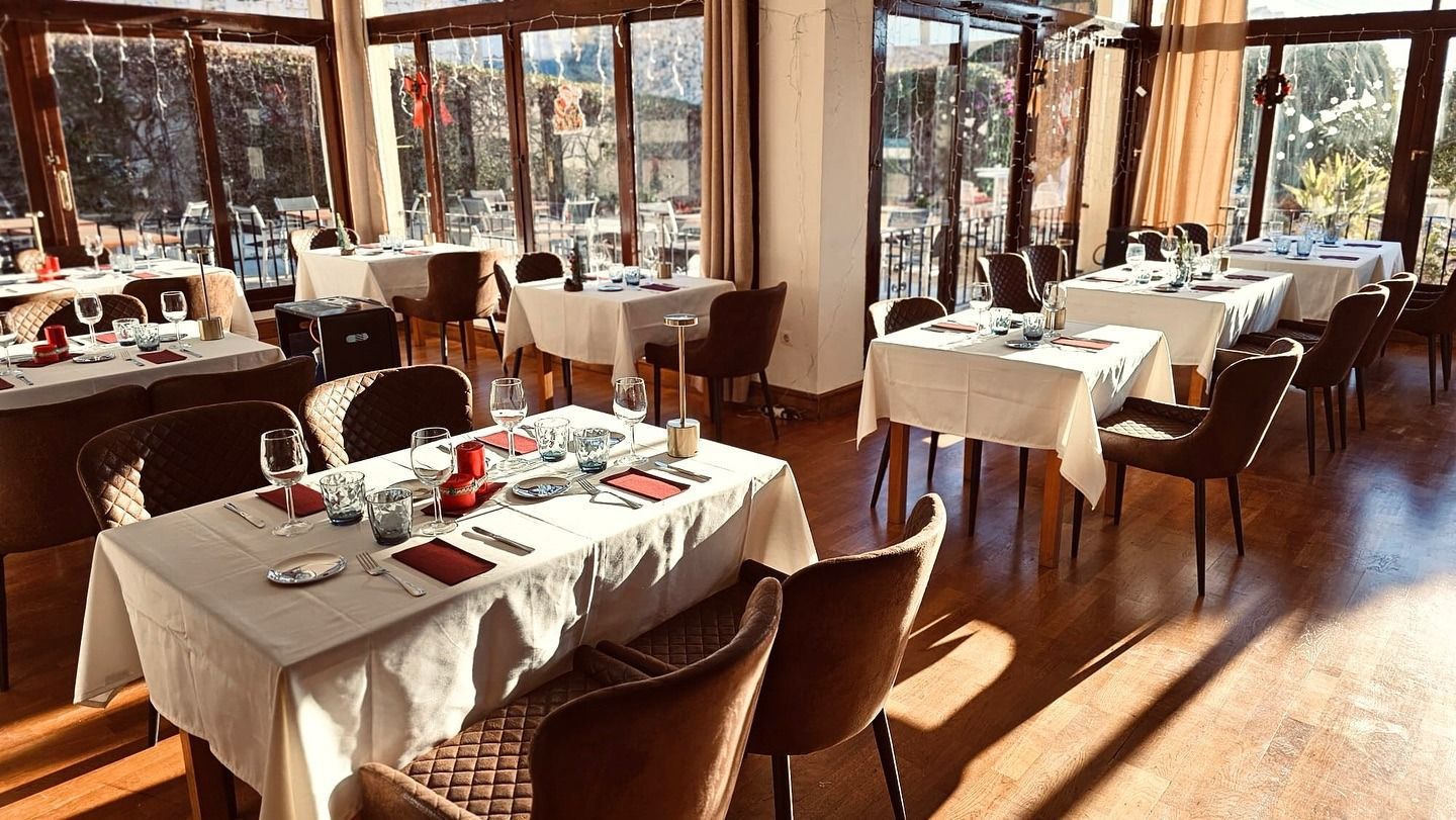 Un restaurante lleno de mesas y sillas y muchas ventanas.