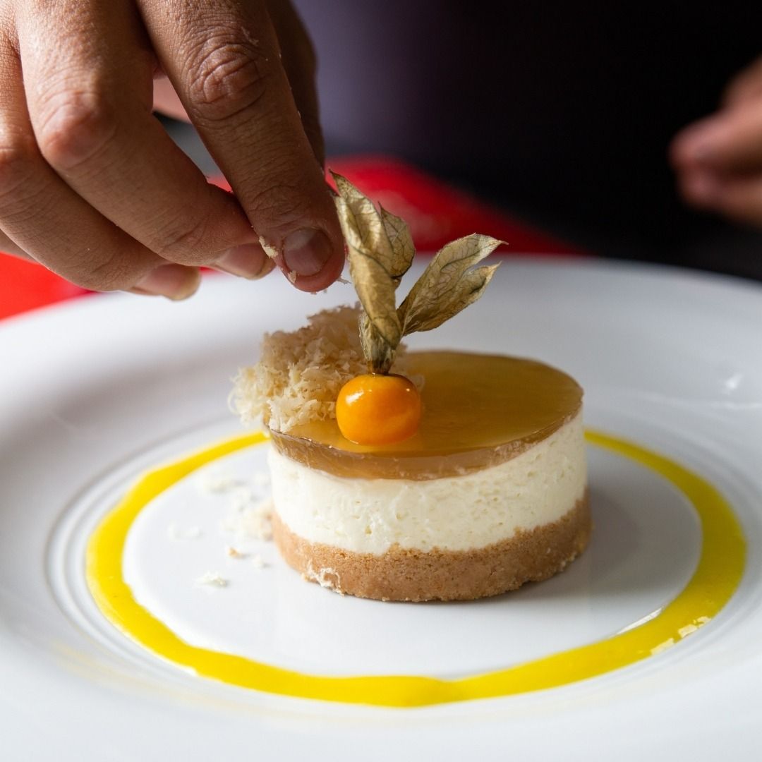 Una persona está decorando un postre en un plato blanco.
