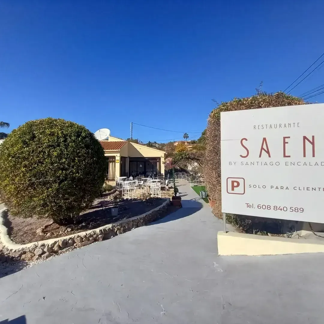 Un cartel que dice saen está frente a un edificio.