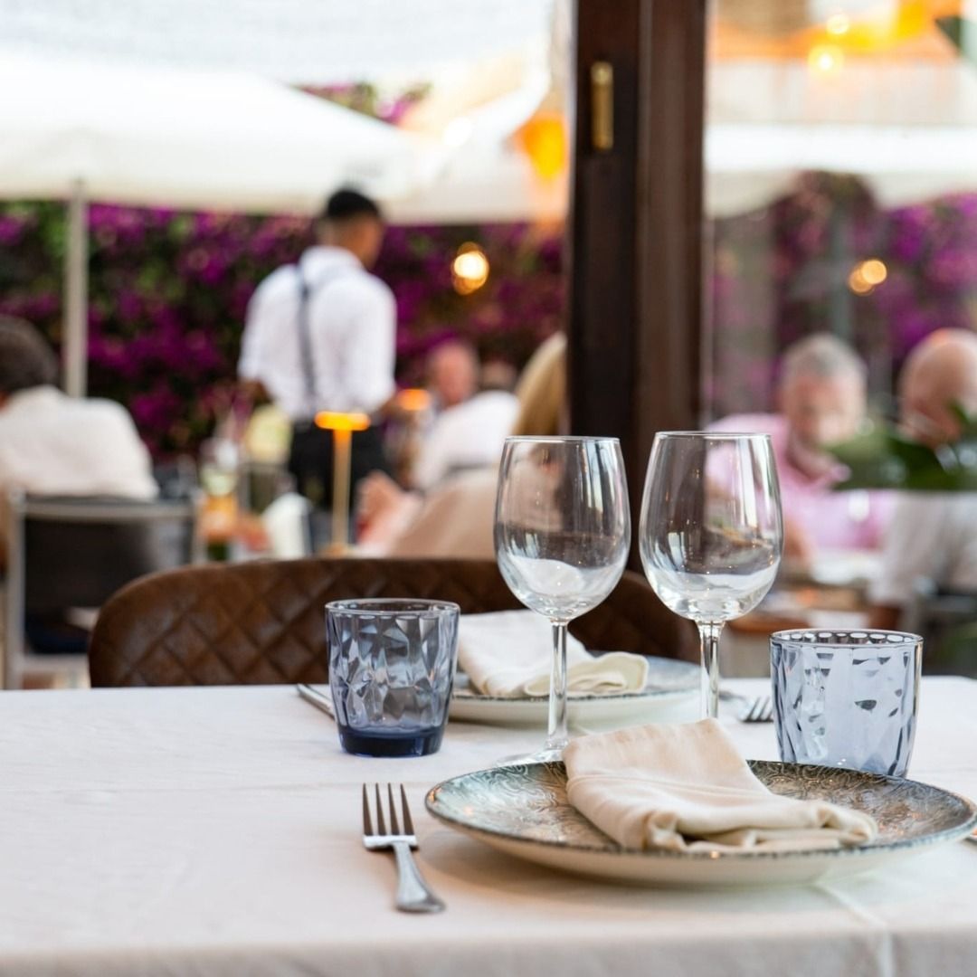 Una mesa de restaurante con platos y vasos encima.