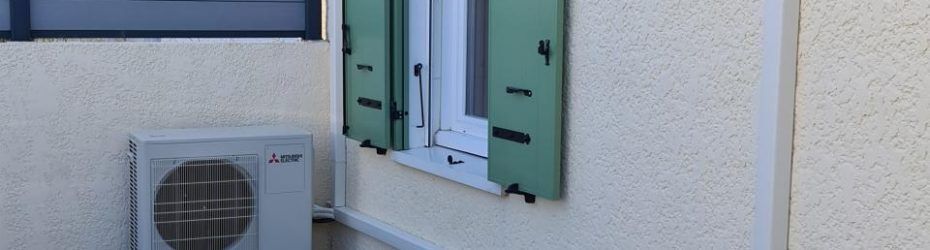 Mur extérieur avec un climatiseur à côté d'une fenêtre à volets verts et d'une porte turquoise