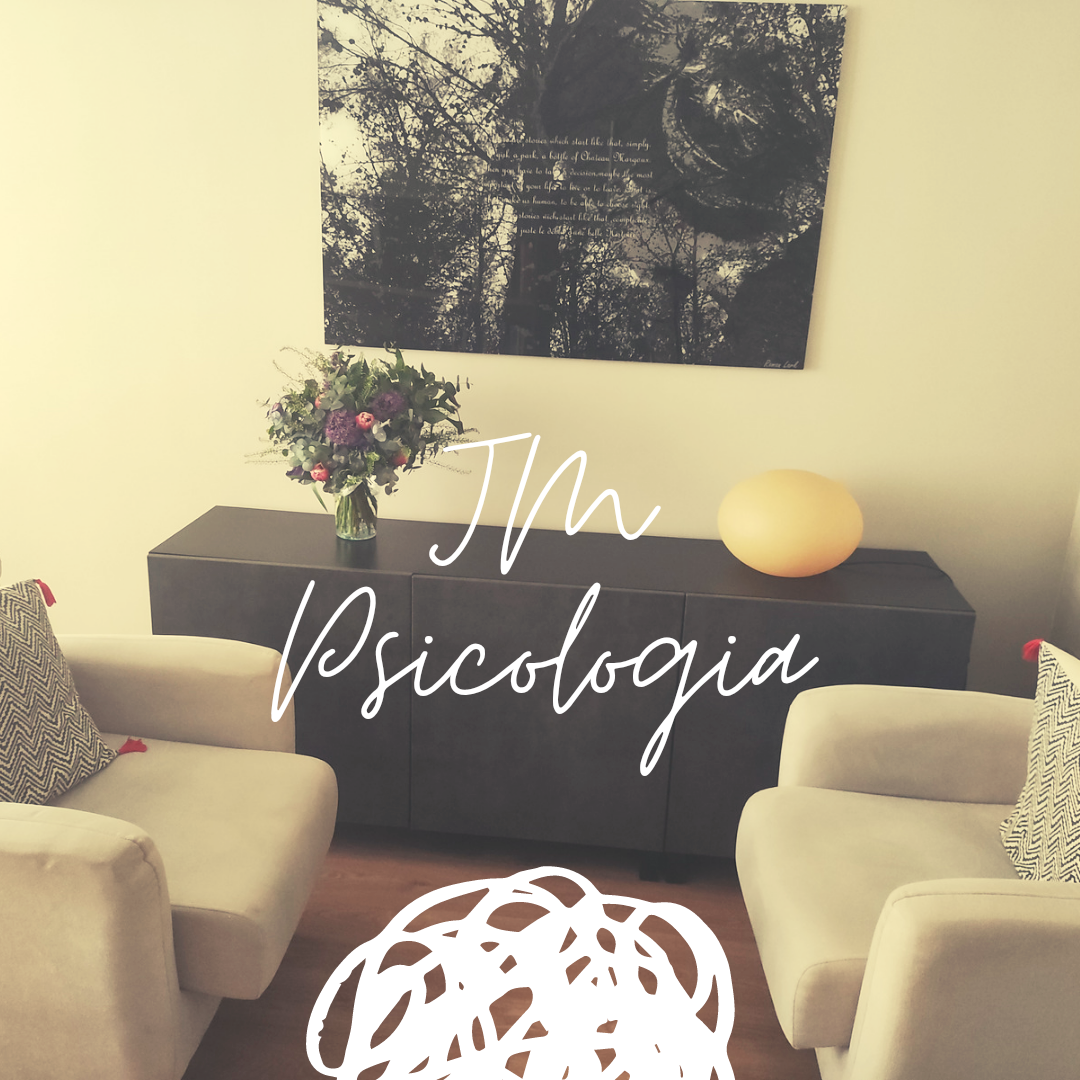 Consultorio de psicolog&iacute;a con dos sillones, un aparador, arte abstracto y un ramo de flores.