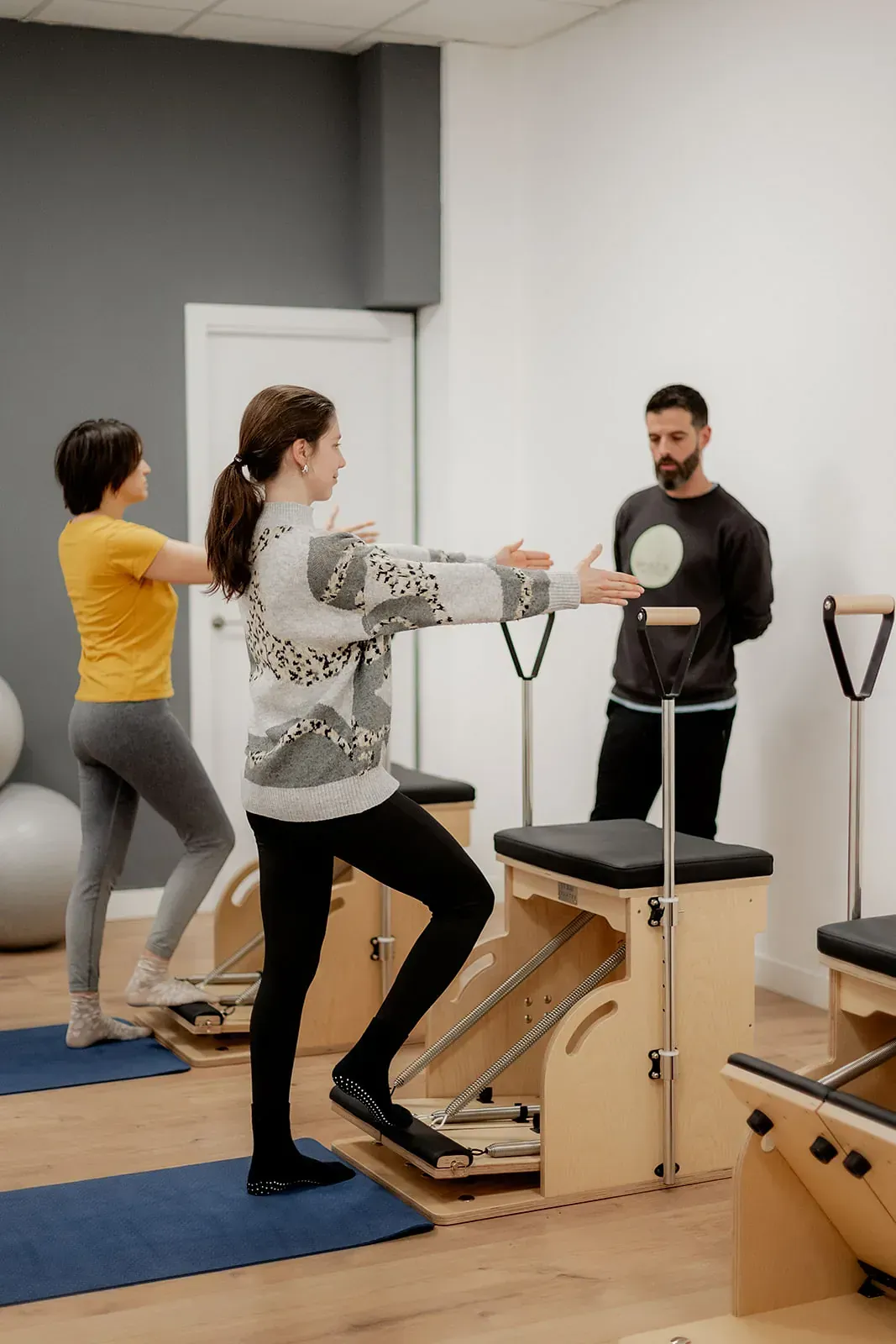 Un grupo de personas está haciendo ejercicios de pilates en un gimnasio.