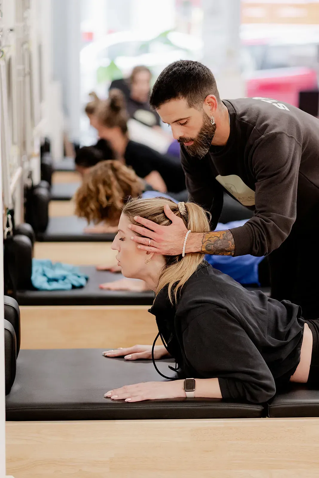 Un hombre está ayudando a una mujer a estirar la espalda en un gimnasio.