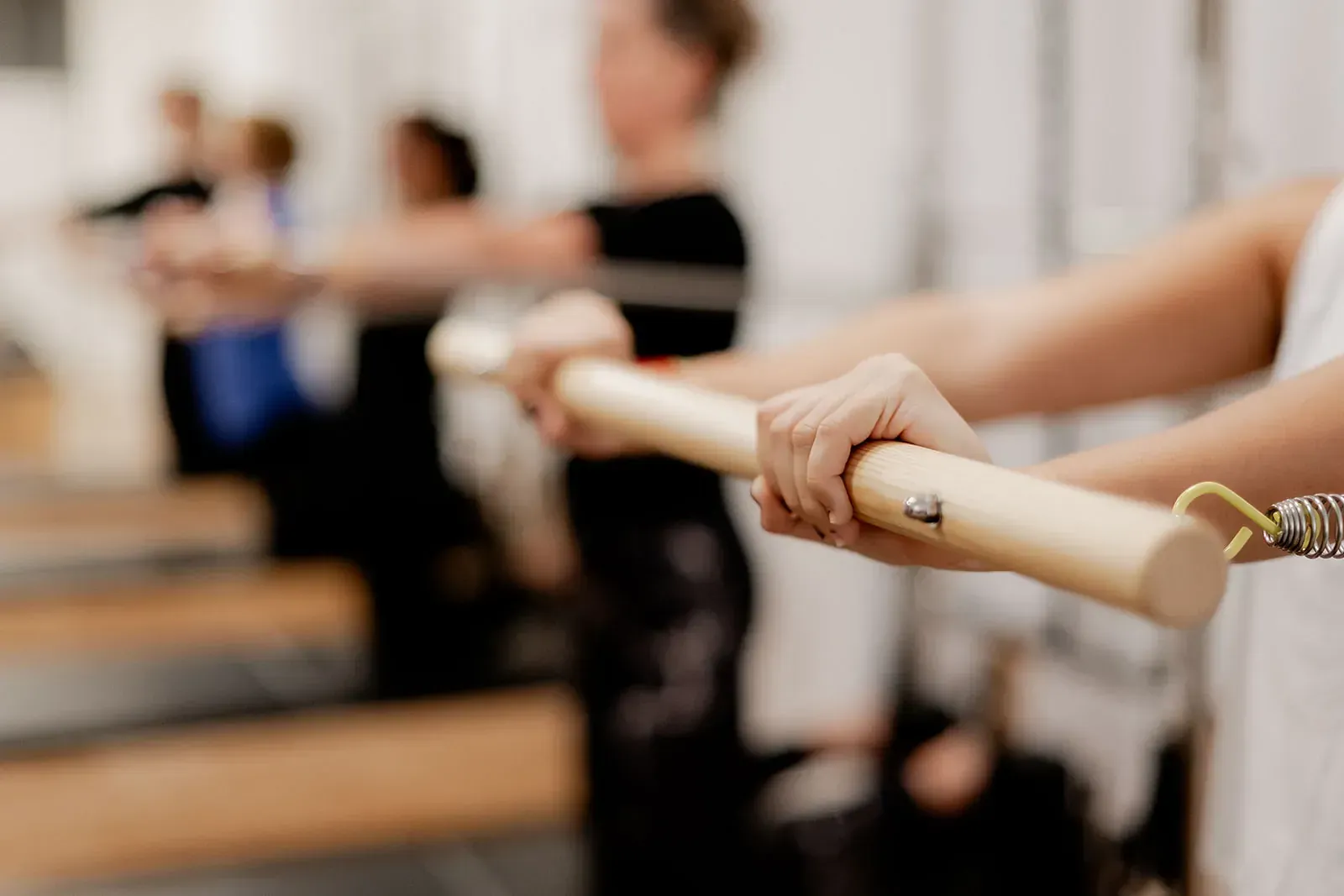 Un grupo de personas sostiene un palo de madera en un estudio de baile.