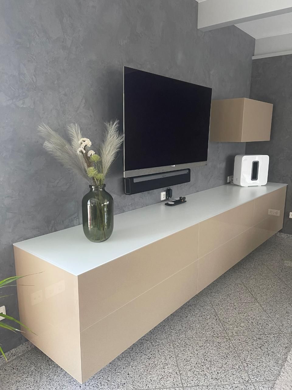 Schreinerei Riethenauer, weißes Sideboard mit Vase und TV an der Wand