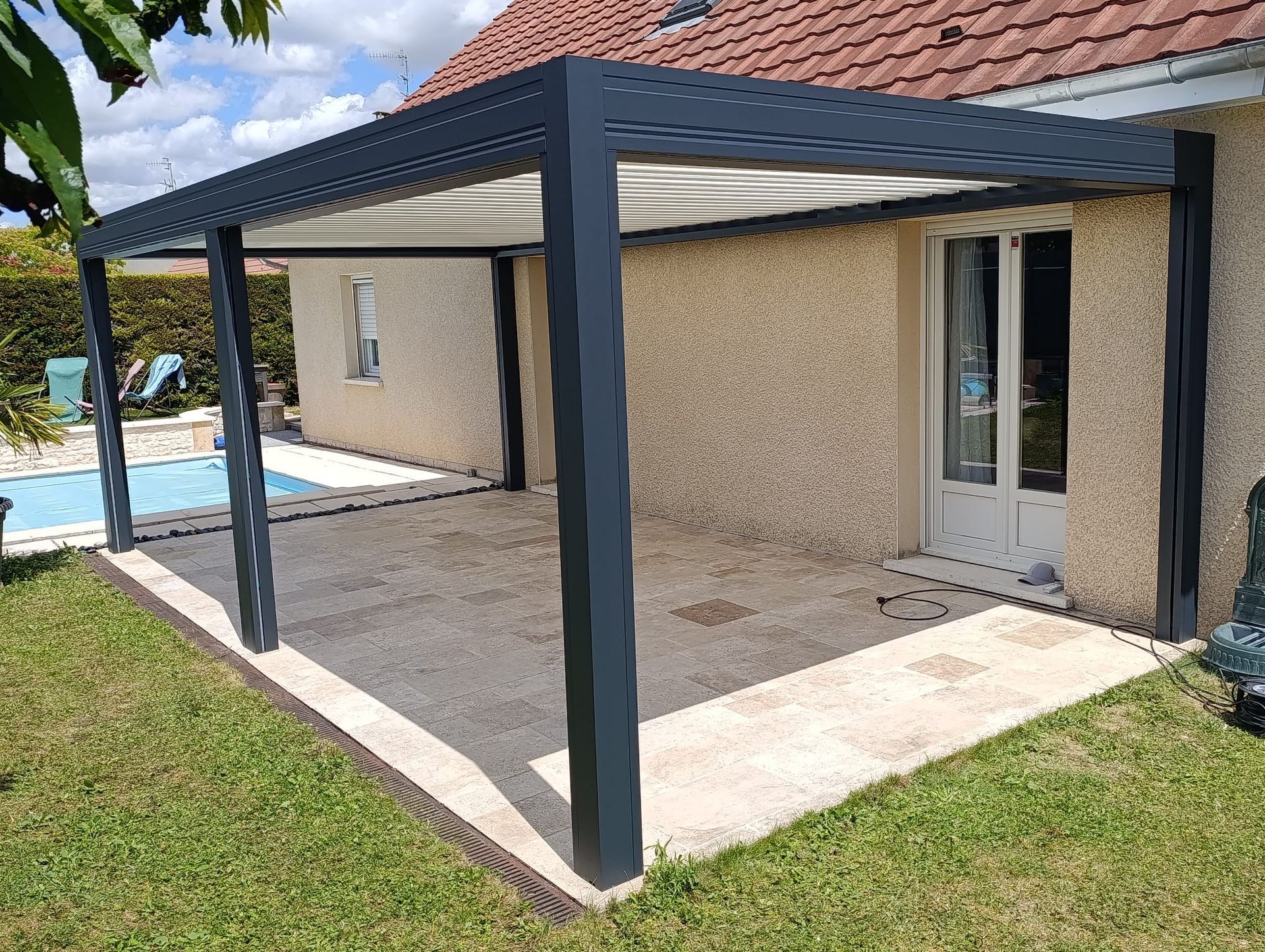 Une belle cour avec pelouse et piscine et pergola