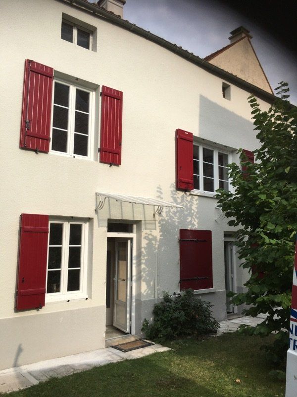 Devanture de maison avec volets rouges