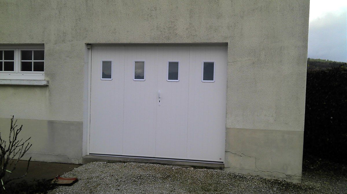 Porte de garage latérale blanche avec carreaux et porte
