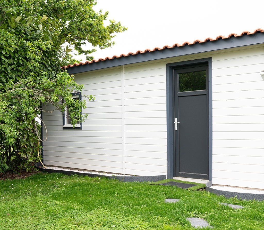 Porte de service grise sur une maison en bois