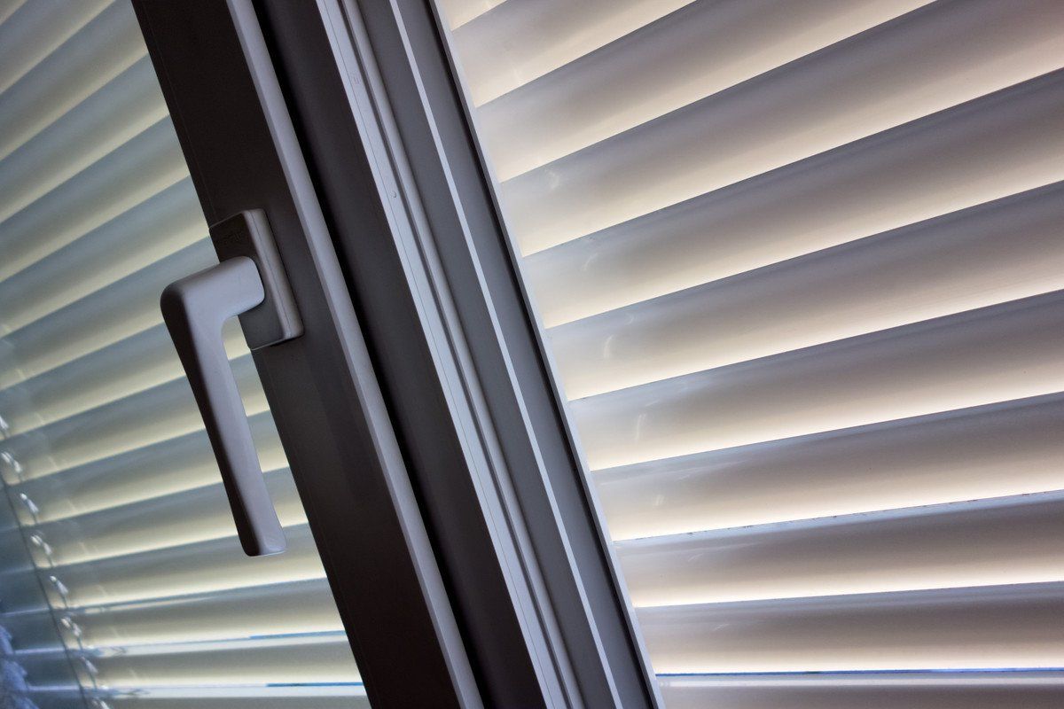 Zoom sur un store blanc à l'extérieur d'une fenêtre