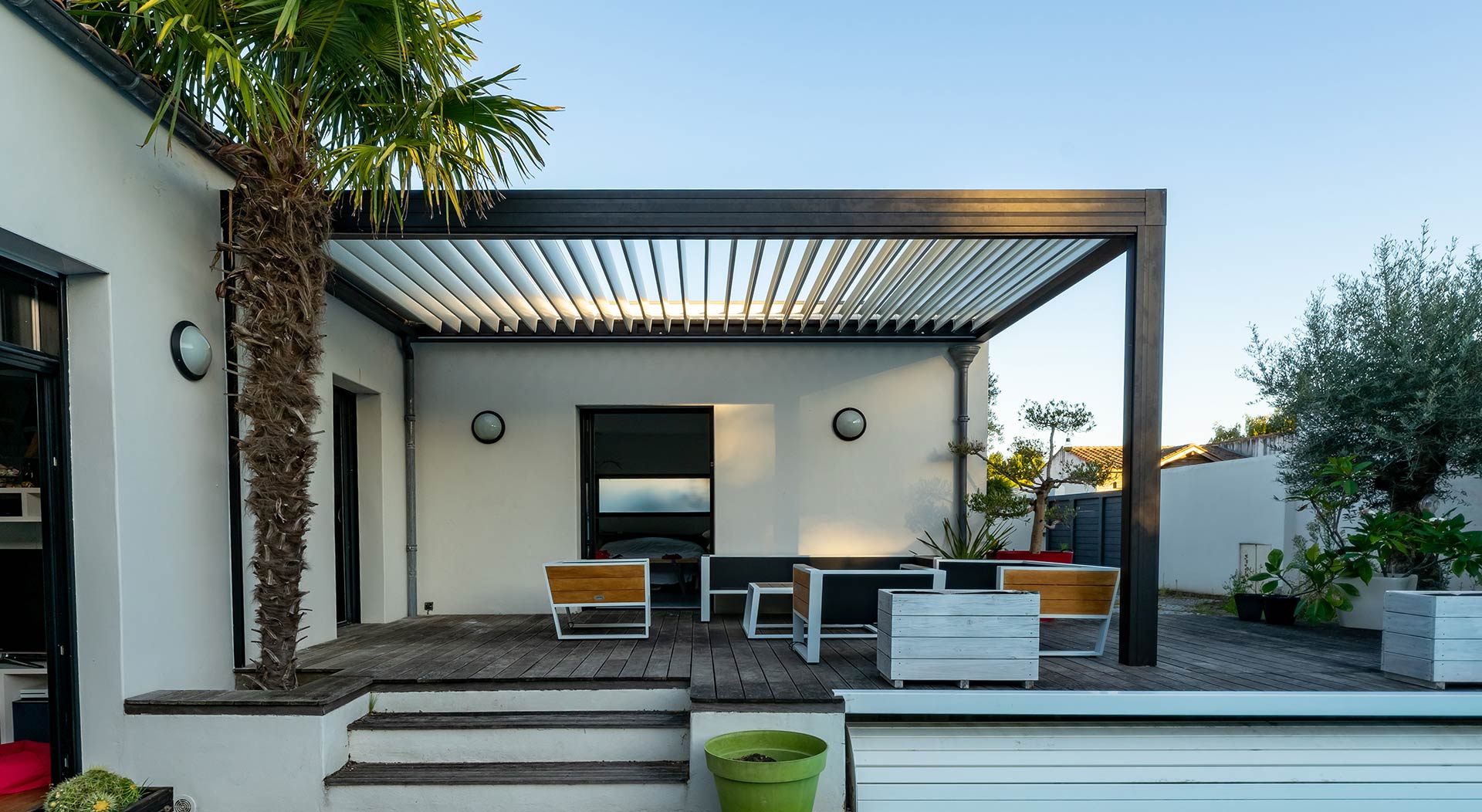 Structure d'ombrage de pergola de patio extérieur tendance, auvent et toit de patio, salon de jardin, chaises, grille métallique entourée d'un aménagement paysager