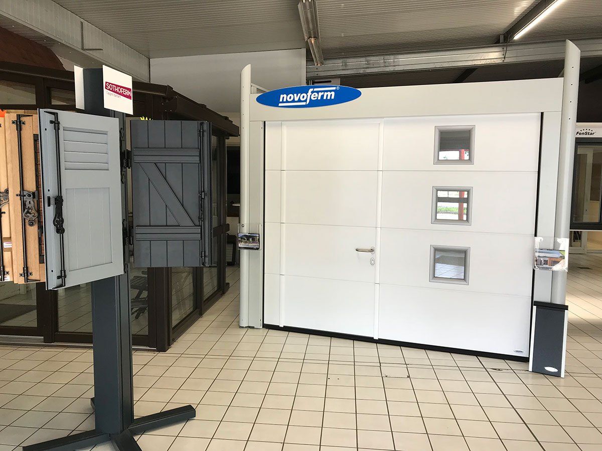 Porte de garage blanche sectionnelle avec une porte de service 