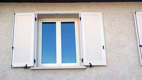 Devanture de maison avec volets blancs ouverts