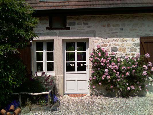 Devanture de maison fleurie avec porte blanche