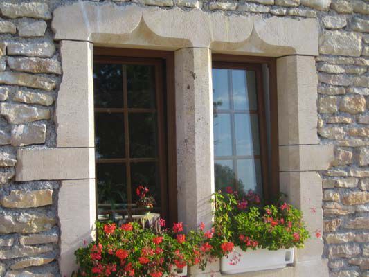 Devanture de maison en pierre avec porte-fenêtre en bois