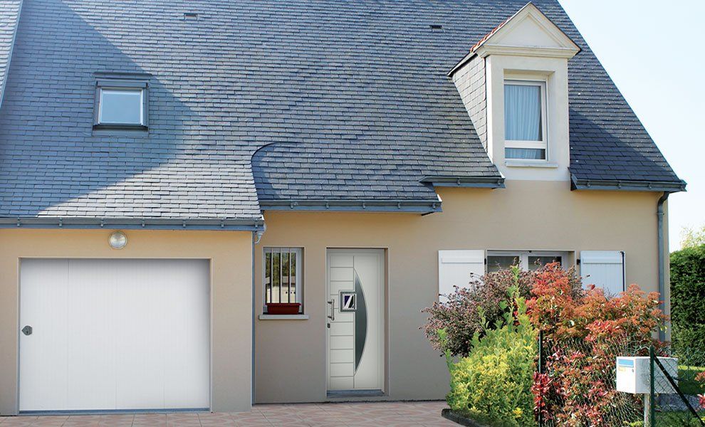 Porte d'entrée blanche d'une maison à la toiture grise