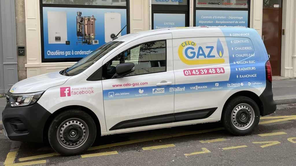 Une camionnette de service blanche portant l'inscription « Oh! Gaz » était garée dans une rue de la ville, présentant des informations sur les services de plomberie et de chauffage.