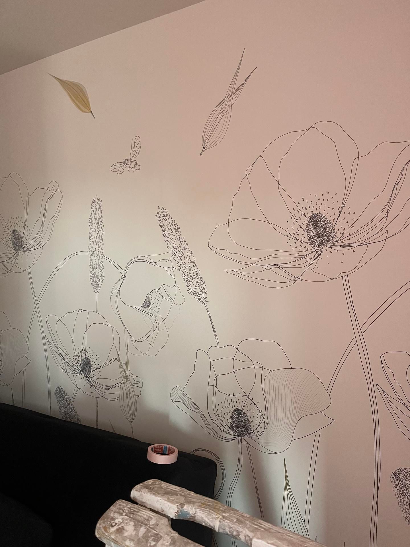 Mur blanc avec un motif floral souligné, comprenant des coquelicots et des feuilles.