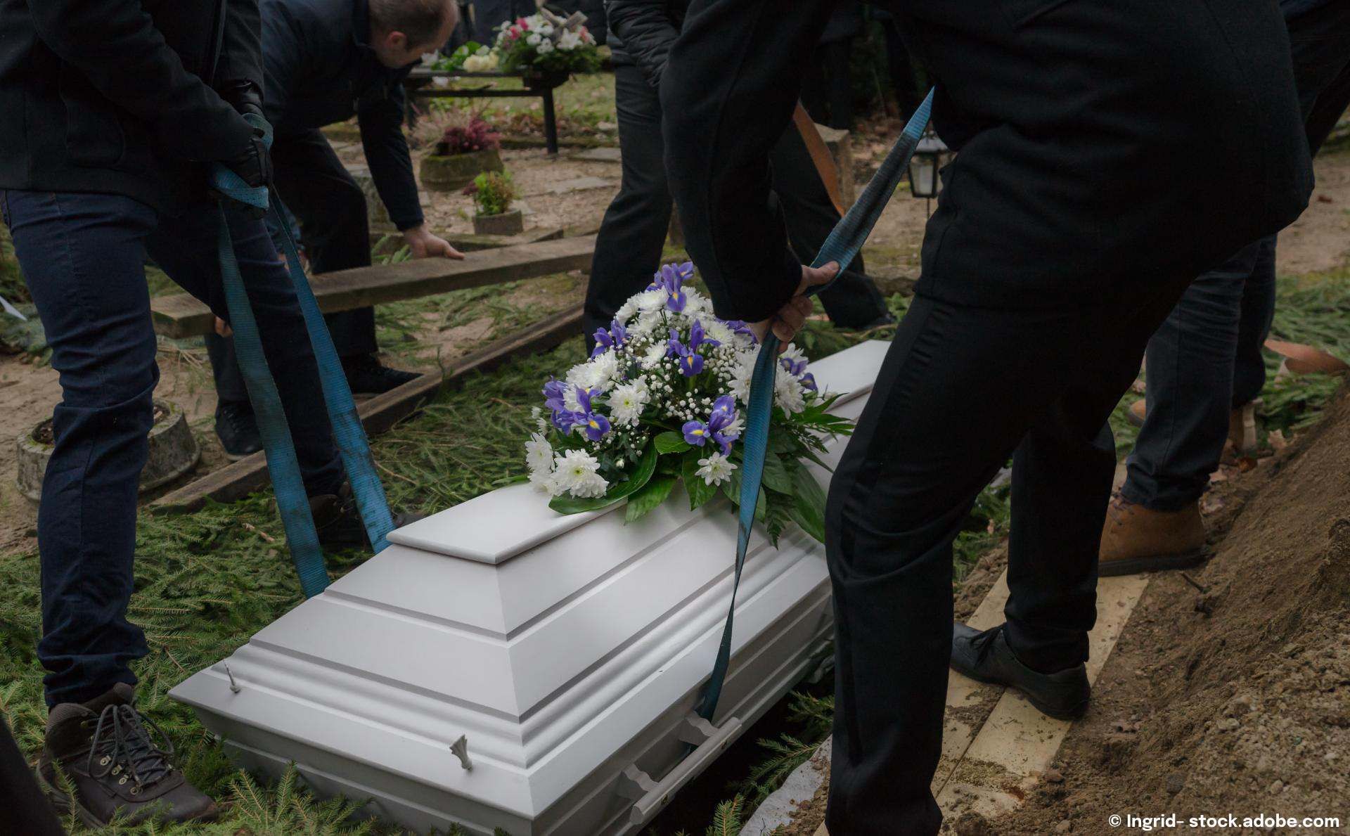 Weißer Sarg und Blumen