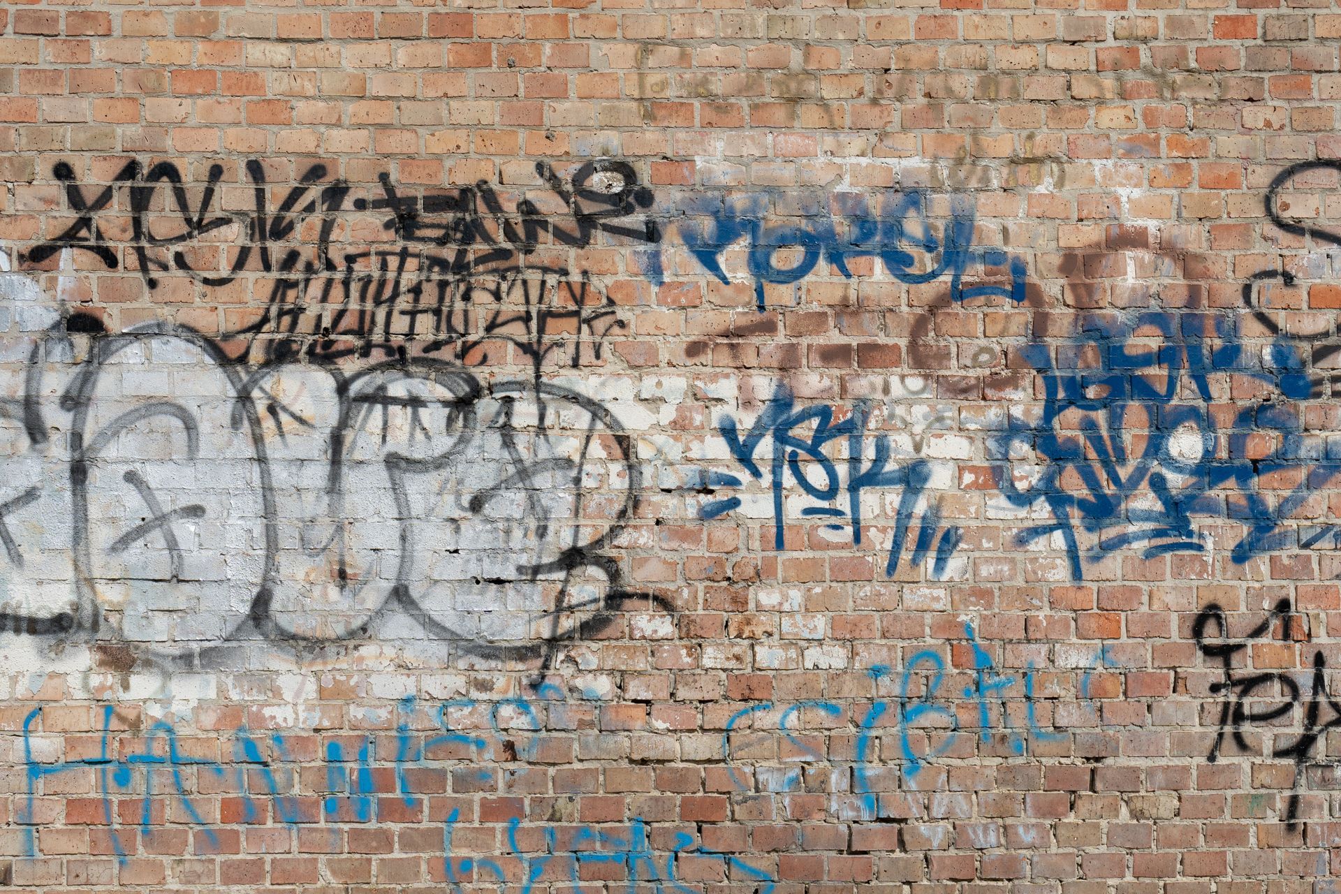 Vers la page Nettoyage graffitis. Des graffitis sur un mur de briques.