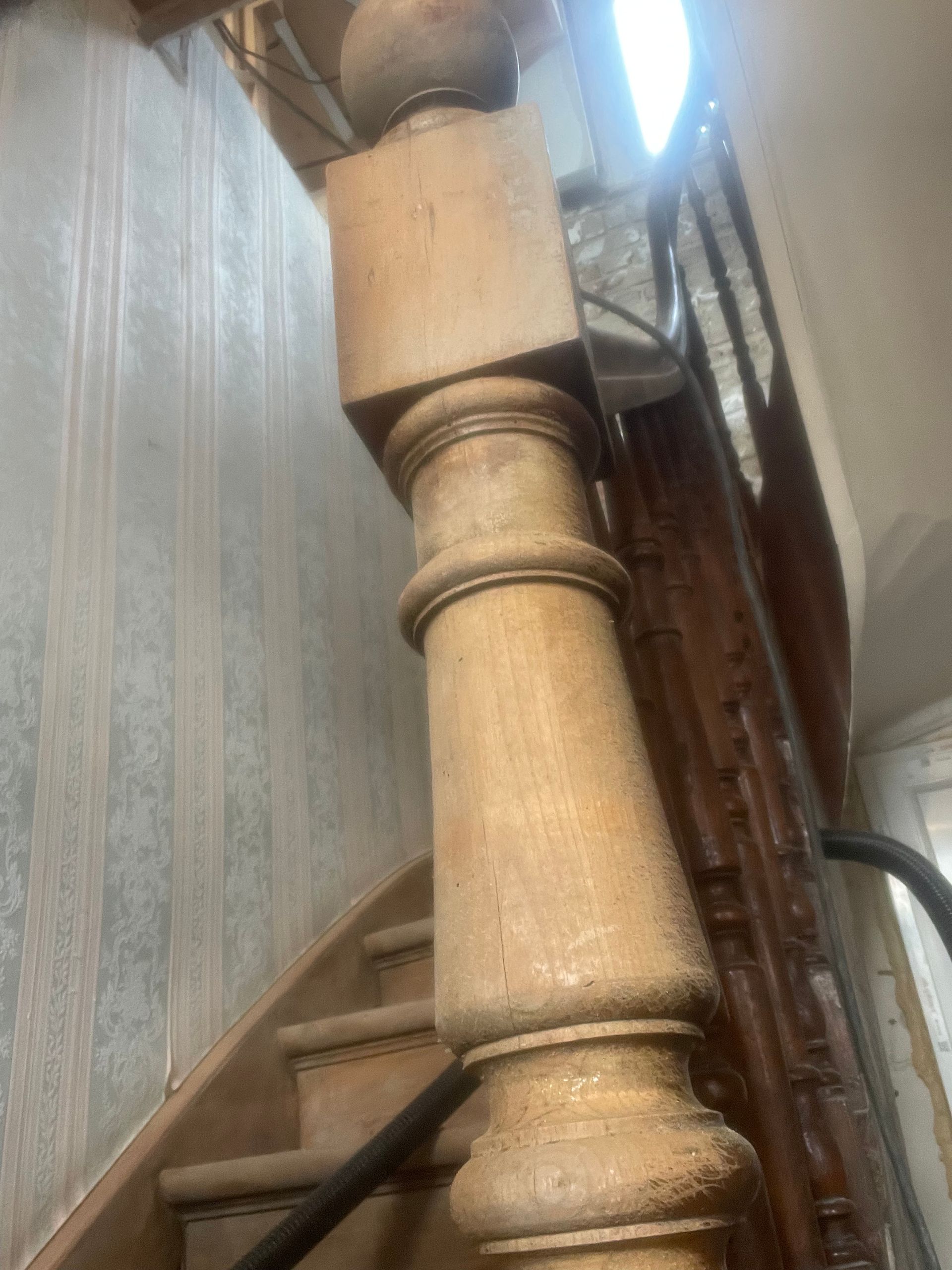 Escalier en bois avec une grande rampe ornée.
