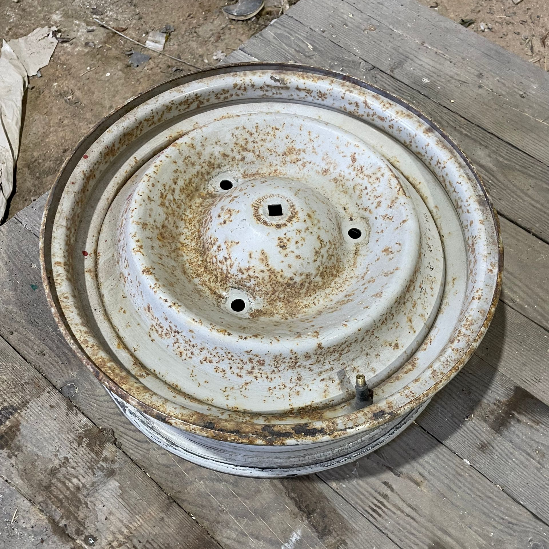 Jantes en métal blanc rouillé sur des planches de bois.