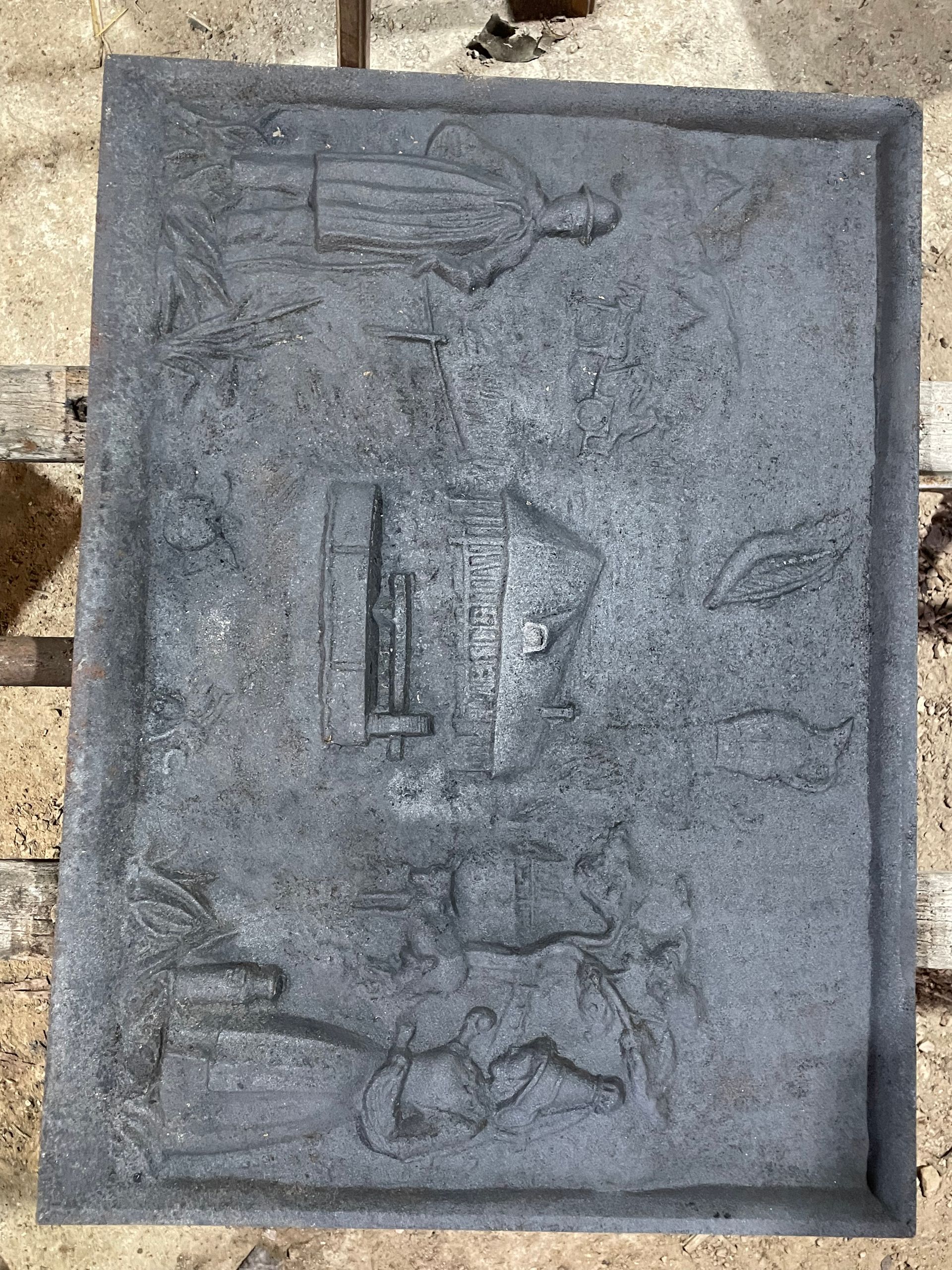 Plaque rectangulaire grise ornée de scènes en bas-relief.