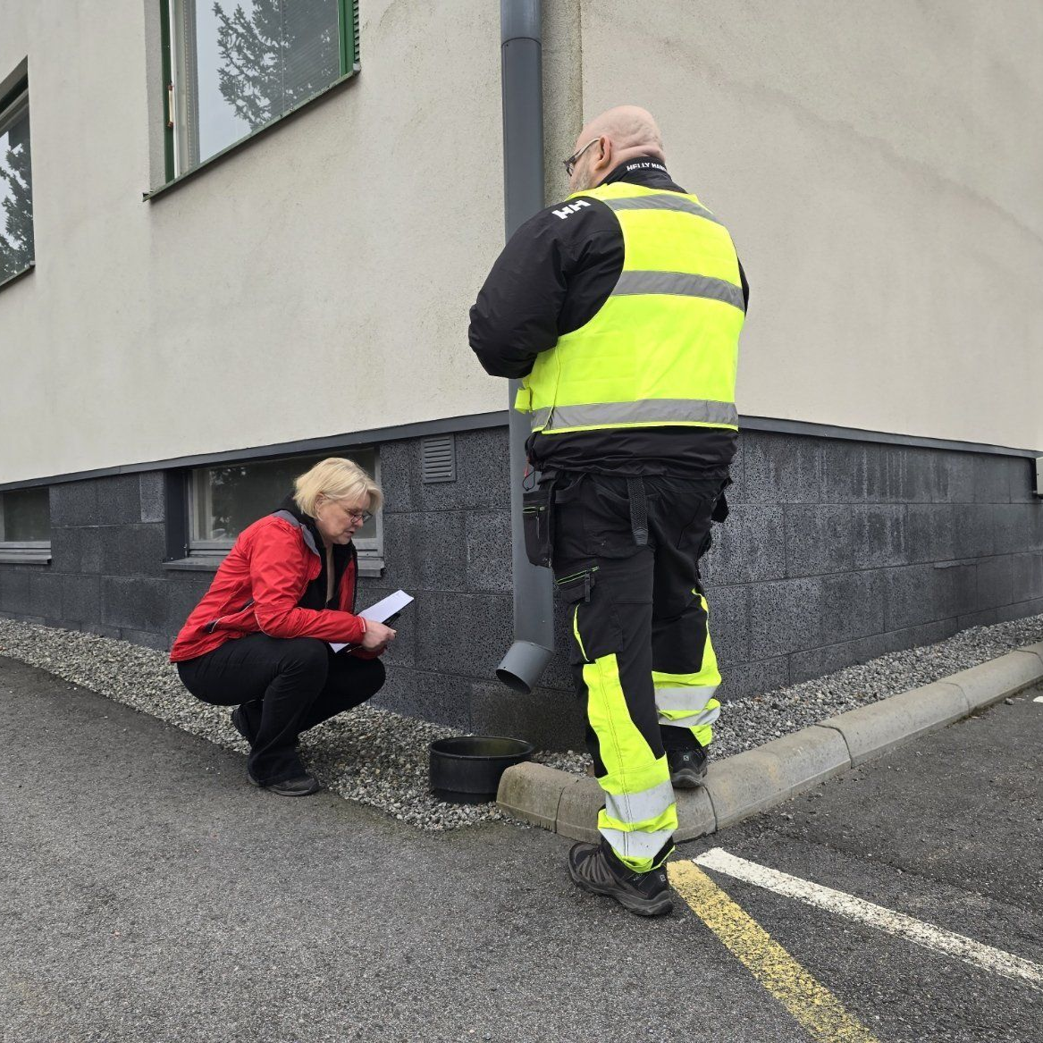 Isännöitsijä ja huoltoyhtiön työntekijä tarkastamassa sadevesijärjestelmien toimivuutta