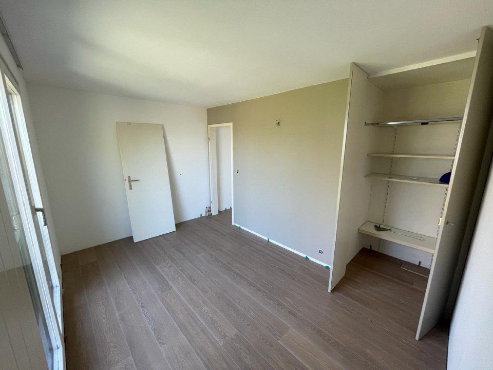 Une pièce vide avec un plancher en bois et un placard.