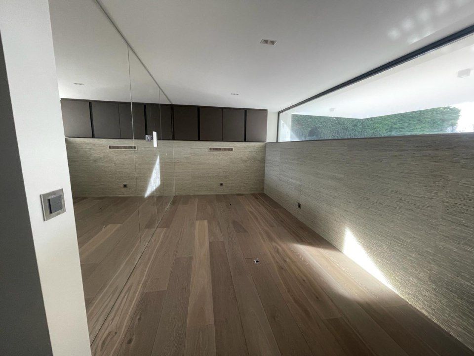 Une pièce vide avec du parquet et une grande fenêtre.