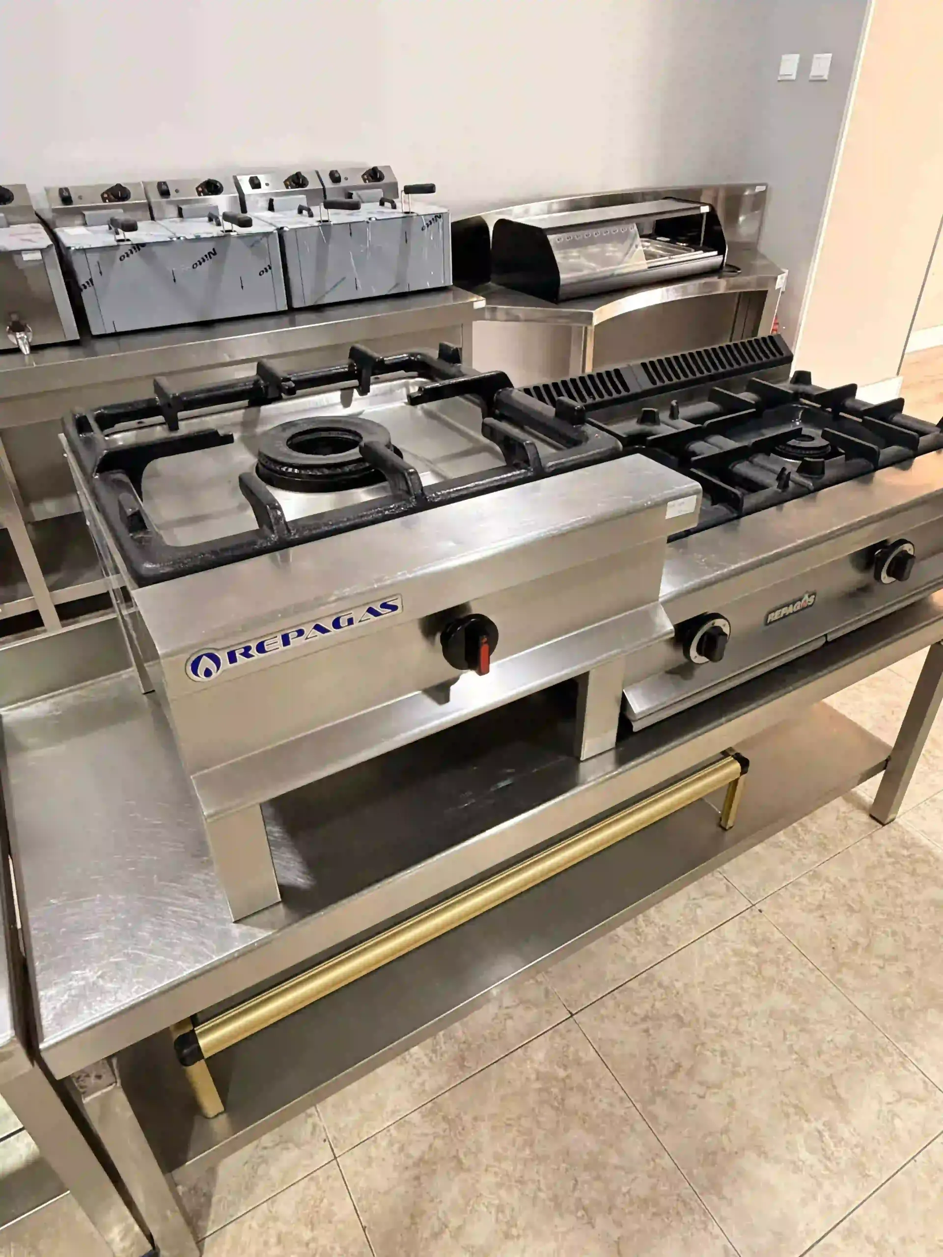 Cocina de gas comercial de acero inoxidable con múltiples quemadores en una exposición de cocinas.