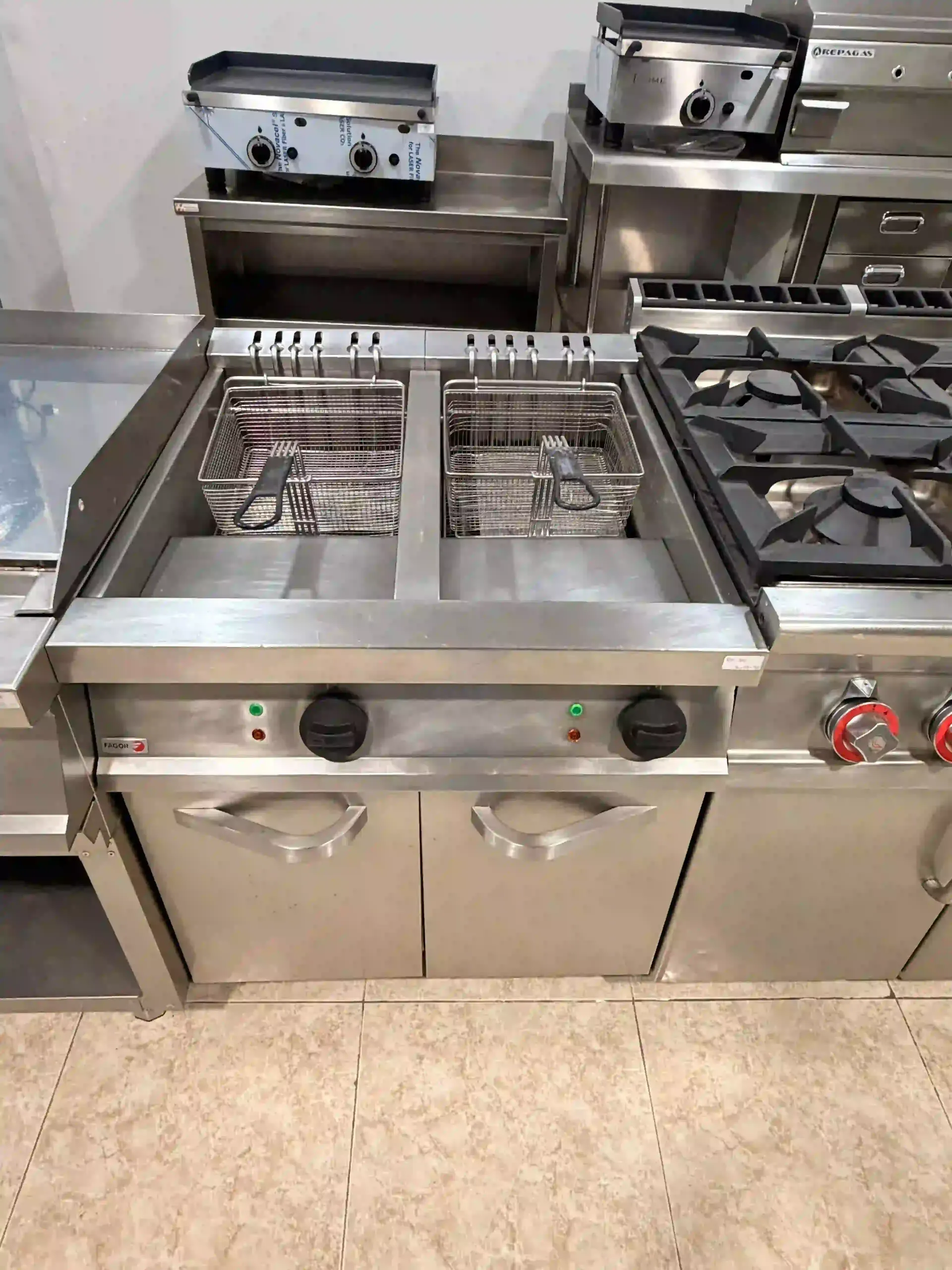 Placa de cocción de gas comercial de acero inoxidable con quemadores y plancha en la cocina de un restaurante.