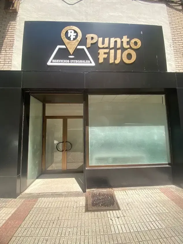 Fachada de un local comercial con un letrero negro que dice 
